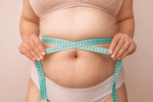 Woman measuring stress belly - belly fat