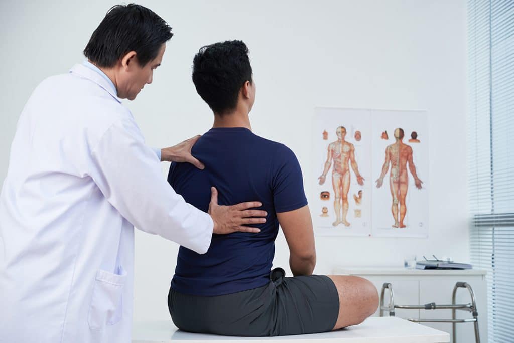 Chiropractor checking man's spine health