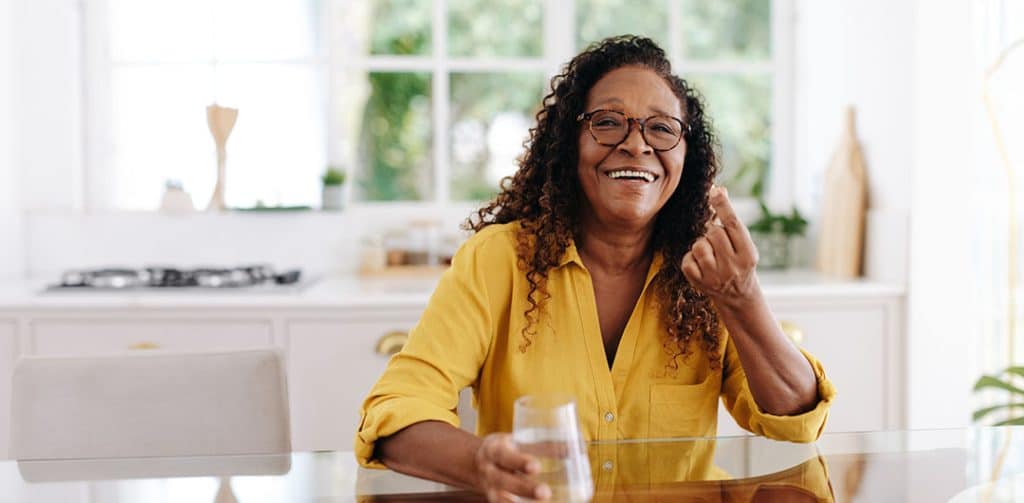 Healthy aging with Omega 3: Woman taking nutrition supplements at home - Benefits of Omega 3 fatty acids