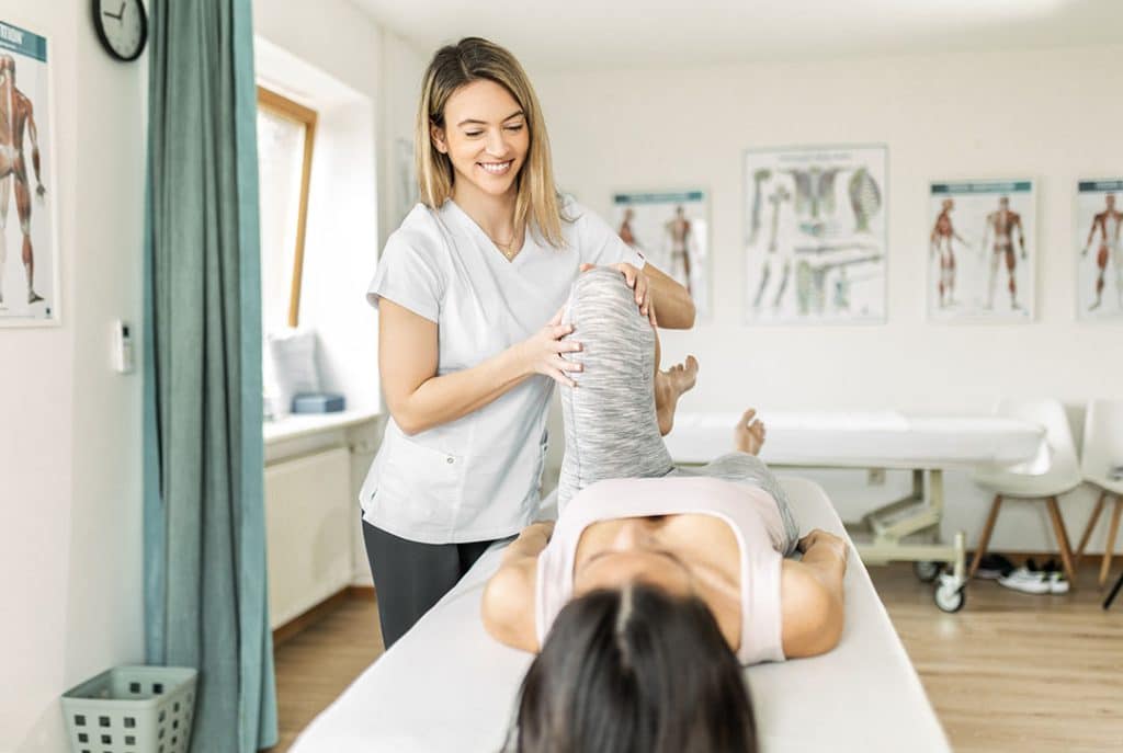 Young female physiotherapist exercising with her patient - Signs of Muscle Imbalance and How to Fix It