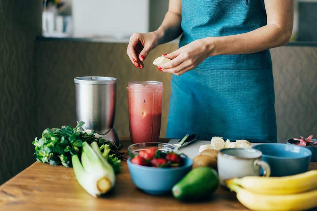 Woman making an allergy-reducing smoothie in the kitchen