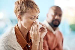 Woman blowing nose - allergy symptoms and how to get natural relief