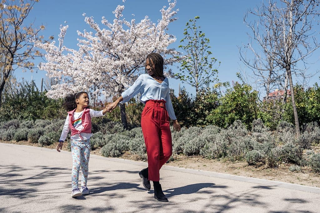 Girl and mom walking in a park on a spring day