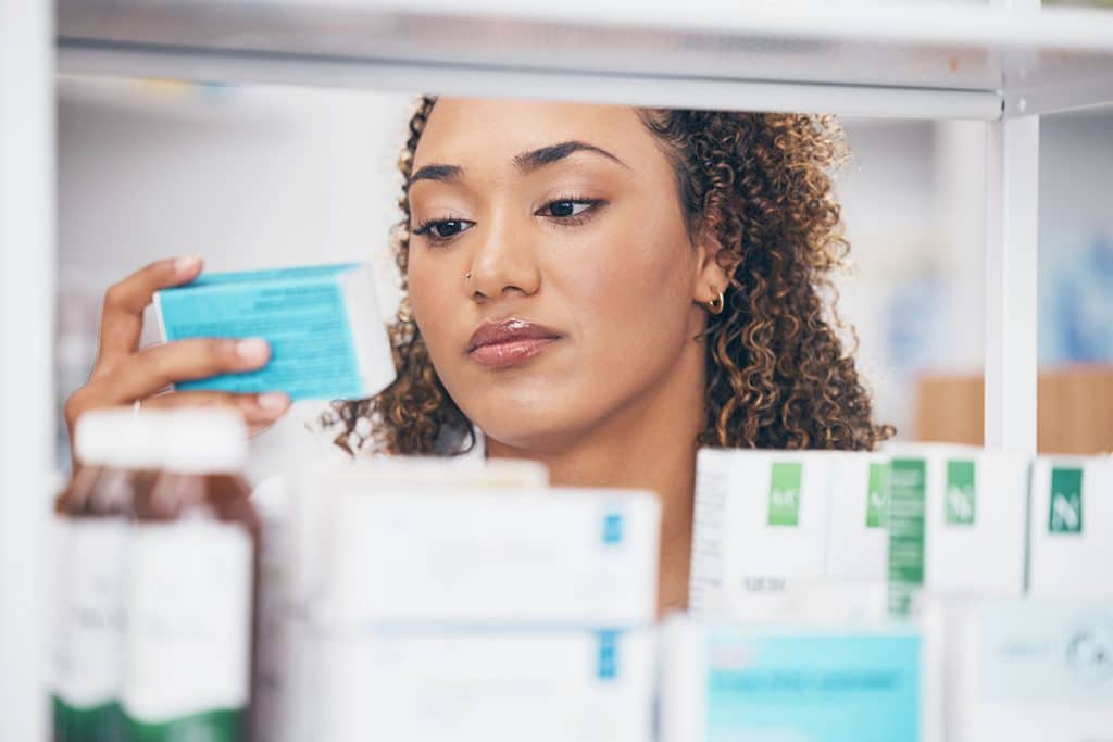 Woman searching allergy medicines on shelf at store - Top Natural Antihistamines