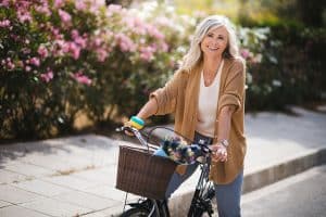 Smiling senior woman having fun riding vintage bike in spring - Spring Cleaning - developing good habits