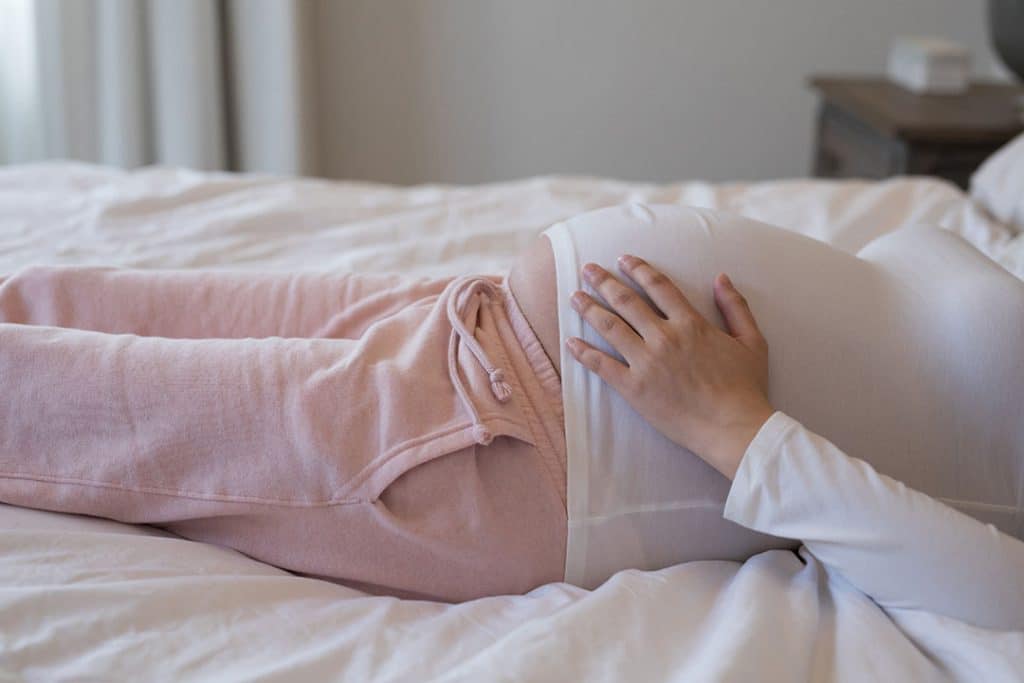 Pregnant woman lying in bed.