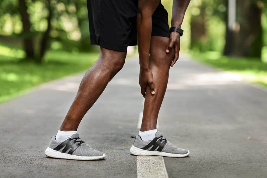 Man with leg cramp walking outdoors