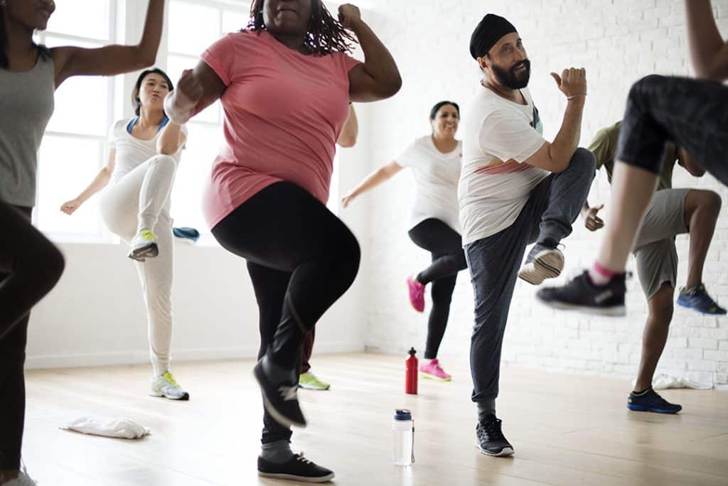 Woman at group fitness class - 7 Strategies to Break the Weight Gain Cycle