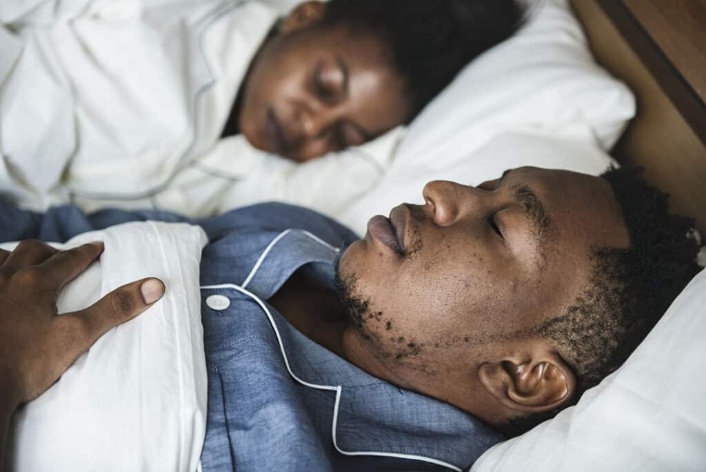 A couple sleeping in bed - sleep for weight loss