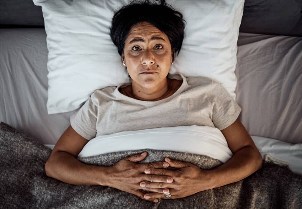 woman lying in bed with insomnia and sleep issues