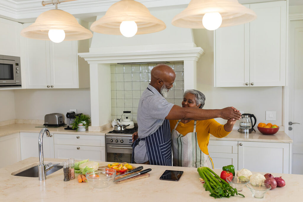 Senior couple dancing together in kitchen smiling. retreat, retirement and happy senior