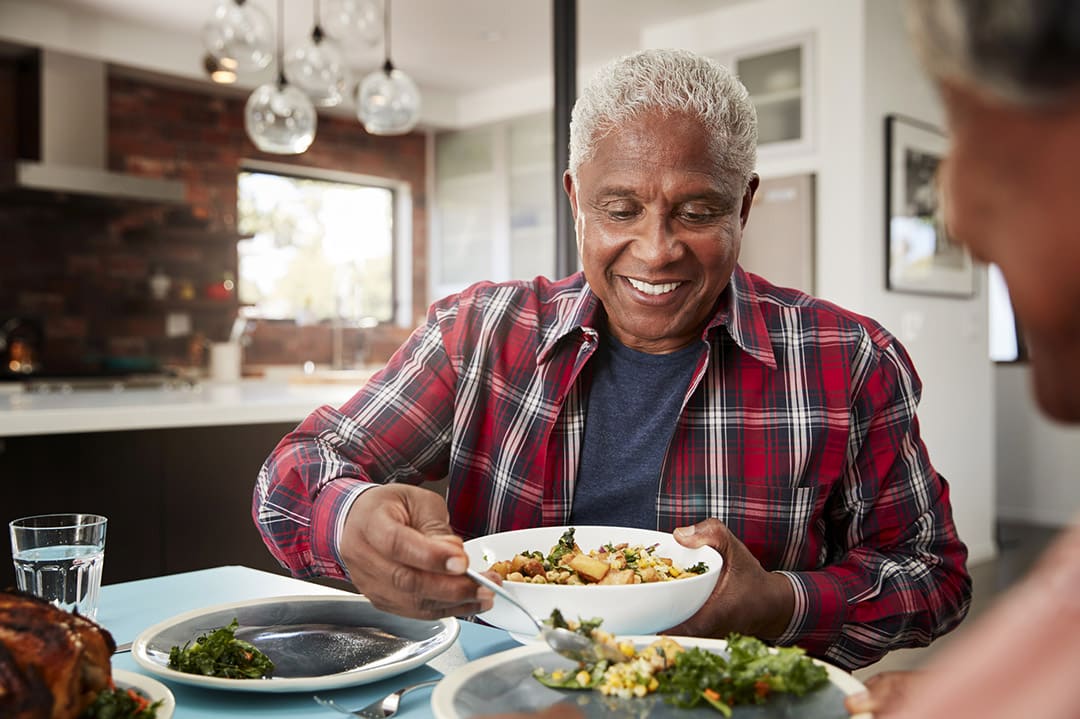 Senior Couple Enjoying Meal Around Table At Home - How To Eat Slower and Get More Out Of Your Food