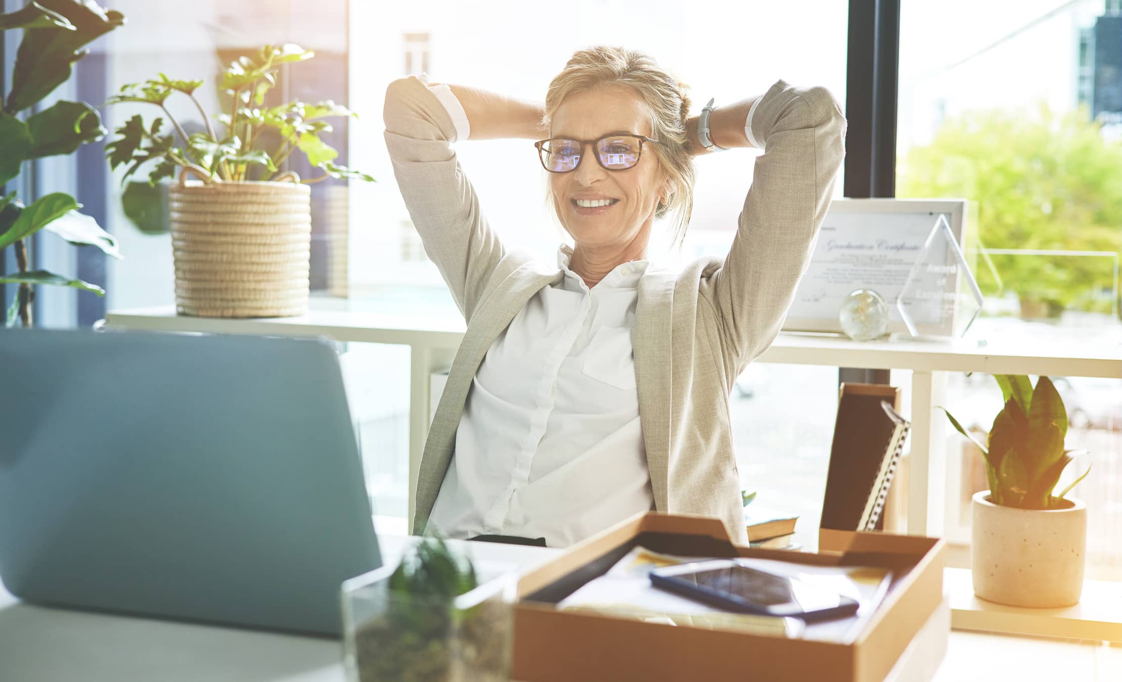 Business woman feeling accomplished and enjoying a break to stretch with hands behind her head in an office. Happy mature entrepreneur satisfied and relieved to have completed her deadlines and tasks thanks to good time management