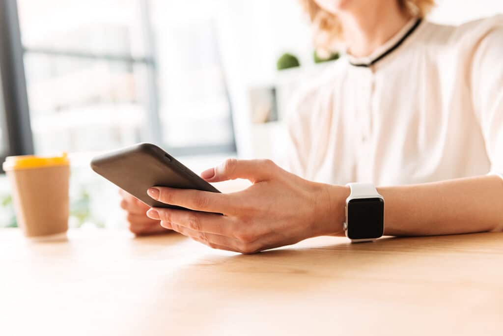 Woman sitting on smart phone tracking food - strategies for eating slower