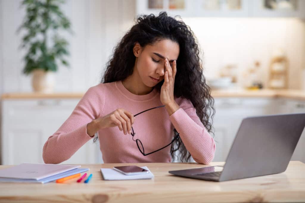 Woman sitting at computer showing stress