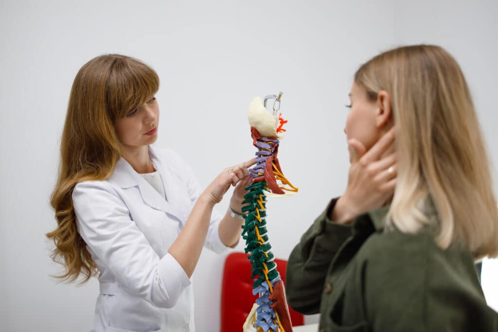 Female chiropractor discussing neck pain stress with patient