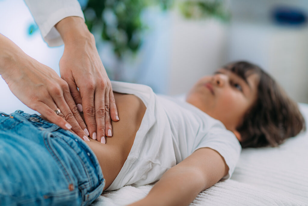 Boy with stomach issues - doctor checking belly - constipation relief for kids