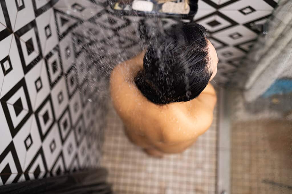 Man in tile shower - Signs of mold in your home