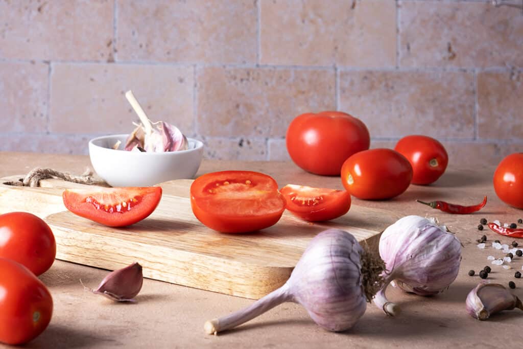 tomatoes and garlic on a cutting board - heart healthy foods