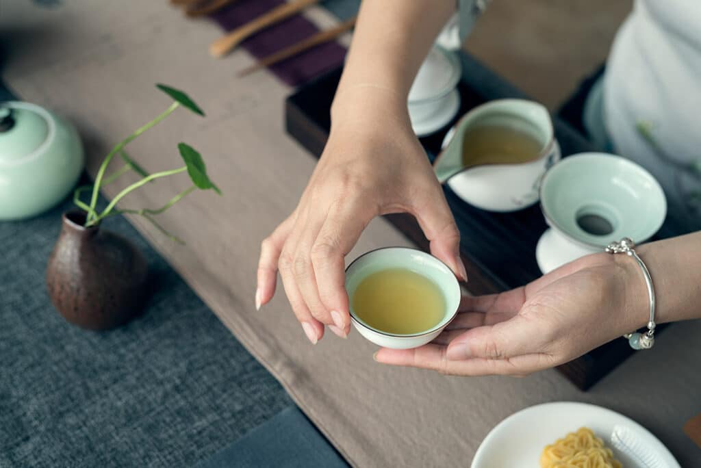 Woman holding a cup of green tea - heart healthy foods