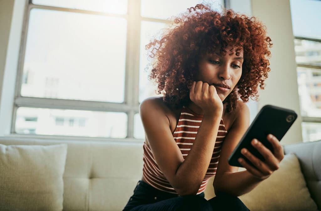 Woman on phone researching - Safety of Chiropractic