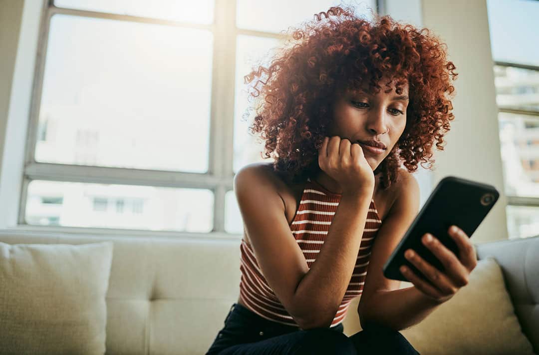 Woman on phone researching - Safety of Chiropractic
