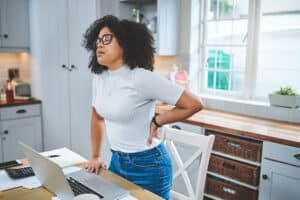Woman with low back pain inflammation at work