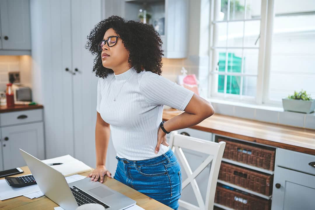 Woman with low back pain inflammation at work