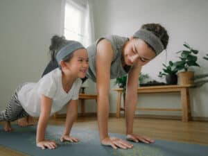 Mom and daughter working out at home - benefits of chiropractic for kids