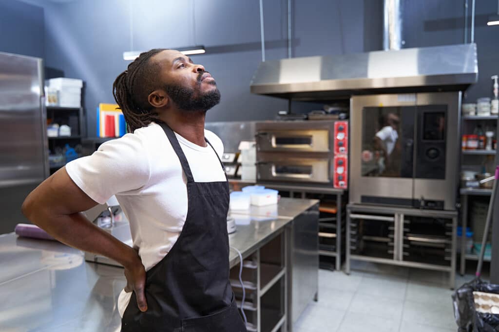 Man working in kitchen with back pain
