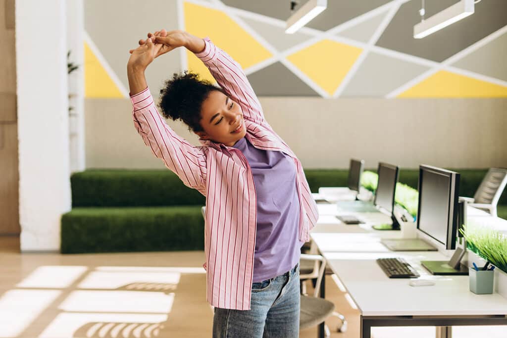 Woman doing back stretches at work to prevent back pain
