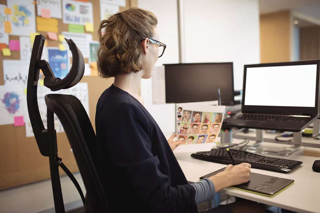 Woman working at desk with proper ergonomics to prevent repetitive strain injury RSI
